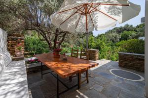 a wooden table and an umbrella on a patio at Small Paradise in Andros