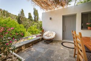 a patio with a chair and a table and a door at Small Paradise in Andros