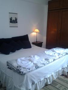 a bedroom with a bed with white sheets and a lamp at Apartment Chunin Depart in Salta