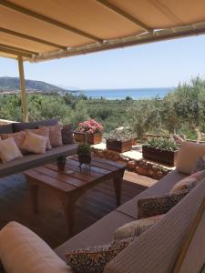 a living room with couches and a table with a view at Riza Apartments in Kardamili