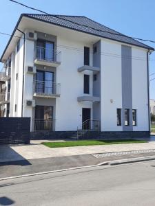 a white building with balconies on a street at Vila Allure in Eforie Nord