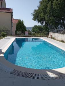 - une piscine d'eau bleue dans la cour dans l'établissement Lila apartmani, à Baošići