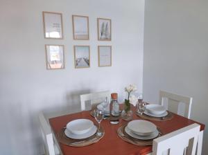 a dining room table with plates and glasses on it at Apartamento AREAL in Fisterra