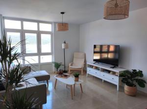 a living room with a couch and a tv at Apartamento AREAL in Fisterra