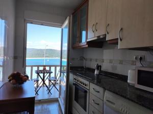 a kitchen with a view of the ocean from a balcony at Apartamento AREAL in Fisterra