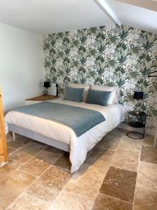 1 dormitorio con 1 cama y papel pintado con motivos florales en La Félicité, 