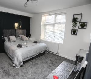 - une chambre avec un grand lit et une fenêtre dans l'établissement Cheerful 4-bedroom home in Sheffield, à Walkley