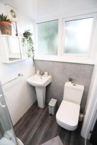 a bathroom with a toilet and a sink at Cheerful 4-bedroom home in Sheffield in Walkly