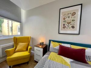 - une chambre avec un lit et une chaise jaune dans l'établissement 1 Bed 2 Person Apartment City Centre, à Cardiff