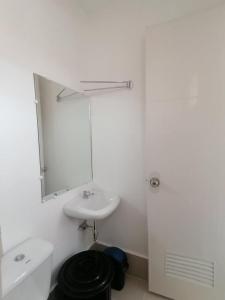 een witte badkamer met een wastafel en een spiegel bij Eurich Furnished Unit 2 in Butuan