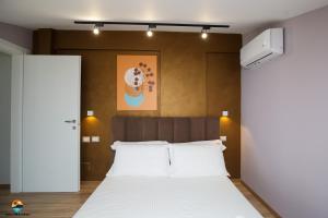 a bedroom with a bed and a painting on the wall at Sunny Hill Residence in Vlorë