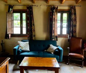 sala de estar con sofá azul y mesa en Casa el Frances, en Candamin