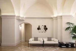 a lobby with two chairs and a koala picture on the wall at Patria Palace Lecce - The Leading Hotels of The World in Lecce