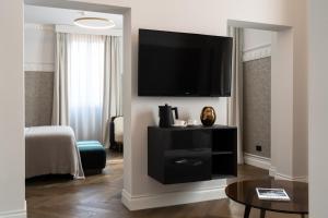 a living room filled with furniture and a tv at Patria Palace Lecce in Lecce