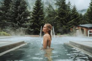 Una donna in piedi nell'acqua in una vasca idromassaggio di QC Termemontebianco a Pré-Saint-Didier