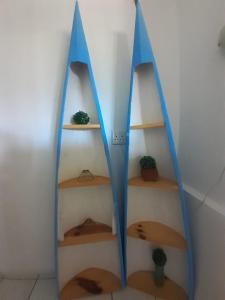 Un estante con tres lienzos azules en una pared. en Valley View at Rocklog Farm, en Howick