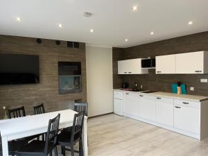 a kitchen with white cabinets and a table with chairs at Wyspówka in Międzyzdroje