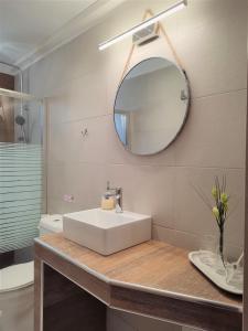 a bathroom with a white sink and a mirror at I&G Studios, Nafplio in Nafplio