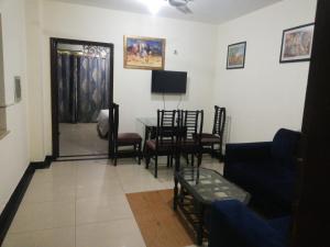 a living room with a couch and a table and chairs at Lovely 1-Bedroom Apartment in Lahore
