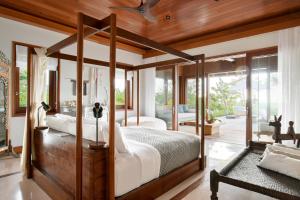 a bedroom with a canopy bed and a living room at COMO Parrot Cay in Sandy Point +208 photos