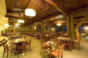un restaurante con mesas y sillas en un edificio en Visual Praia Hotel, en Natal