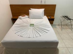 uma grande cama branca com uma ventoinha em Aquarius Hotel Aquarius em Ariquemes