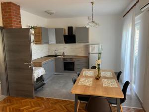 een keuken met een tafel en een eetkamer bij Apartmani Katica in Novalja