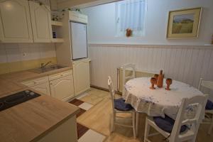 uma cozinha com uma mesa com cadeiras e um frigorífico em The Village Rest - Brezje Gorenjska em Brezje