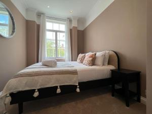 een slaapkamer met een bed en een raam bij STAY IN STYLE OPPOSITE WINDSOR CASTLE & free parking in Windsor