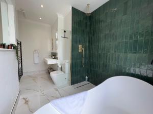 een badkamer met een toilet en een groene betegelde muur bij STAY IN STYLE OPPOSITE WINDSOR CASTLE & free parking in Windsor