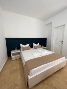 a bedroom with a large bed with a blue headboard at Vila Puky in Neptun