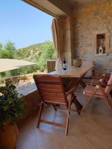 a wooden table and chairs on a patio at Riza Apartments in Kardamili