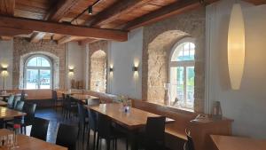 a restaurant with wooden tables and chairs and windows at Hotel Balsthal in Balsthal