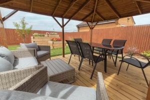 a patio with a table and chairs on a deck at Cedar Drive, Holbeach - 1 to 4 - Self Catering in Holbeach