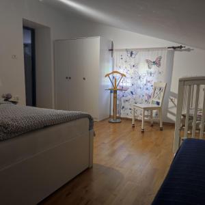 a bedroom with a bed and a table and a chair at Apartma Hiša Pliska in Pliskovica