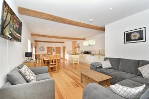 a living room with a couch and a table at 5 Bed Barn Conversion - with private hot tub in Birchington