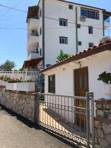 a house with a fence and a building at Vila Eriseld in Ksamil