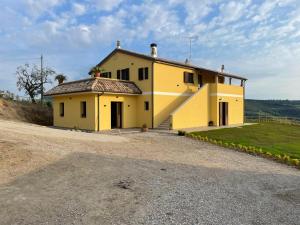 una casa gialla in cima a una collina di Lí da Ste a Ripatransone