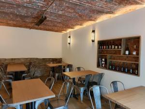 una fila de mesas y sillas en un restaurante en Hotel Le Moulin Des Ramiers, en Crupet