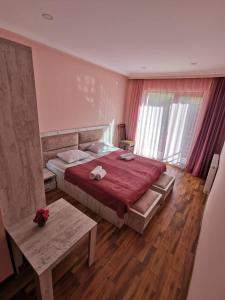 a bedroom with a large bed with a red blanket at Hotel Ramaz Paliani in Mestia