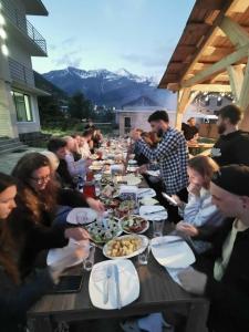 a group of people sitting at a long table eating food at Hotel Ramaz Paliani in Mestia