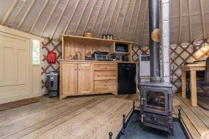 a kitchen with a wood stove in a yurt at Yurt with Hot Tub near Hartington, Peak District in Buxton
