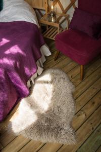 a furry rug laying on the floor next to a bed at Yurt with Hot Tub near Hartington, Peak District in Buxton