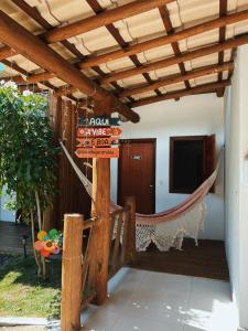 een veranda met een hangmat en een bord met de tekst Navaho Village bij Pousada Aconchego in Caraíva