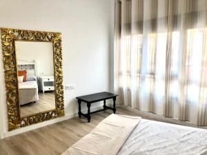 a mirror in a bedroom with a bed and a table at Apartamento Fuerteventura in Puerto del Rosario