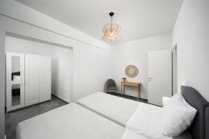 Habitación blanca con cama y escritorio en The H Experience Blackbird Spacious 2BD Apartment close to the beach, en Xylokastro