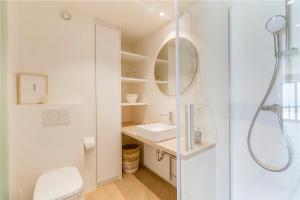 a white bathroom with a sink and a shower at Moderne studio met fantastisch frontaal zeezicht in Nieuwpoort