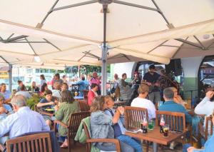 a group of people sitting at tables under umbrellas at Aux Temps d'Em in Montreuil-sur-Mer