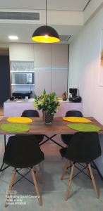 a kitchen with a wooden table with chairs and a dining room at Paiva Home Stay Aptº temporada in Recife