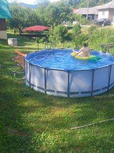 a woman is in a pool in the grass at Chata Pod kopcom in Starina